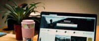 A Tidy Desk Setting With A Laptop Showing A Stock Photo Website And A Smartphone.