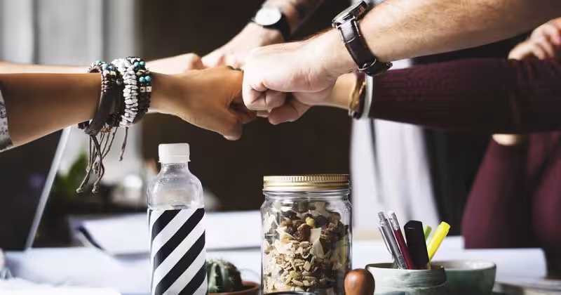 A Group Of People Fist Bumping